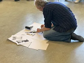 Michael zeigt, wie er mit Farbe und Papier Bilder entwirft